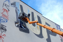 Gesamtansicht des 1UP x Fanakapan Bubble Piece 2019: große ‘1UP’ Buchstaben auf heller Fassade mit Hebebühne.
