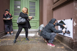 Street-Art-Aktion von Blek le rat mit Schablonentechnik im öffentlichen Raum, begleitet von Dokumentation und Publikum.