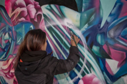 Wandkunst von Hueman auf dem Lollapalooza Festival, die lebendige und abstrakte Porträts in kräftigen Farben zeigt.