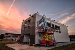 Fanakapan beim Bemalen einer Wand auf dem Lollapalooza Festival, mit einer lebhaften Darstellung von aufblasbaren Objekten.