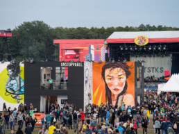 Wandkunst von Snik und Uriginal auf dem Lollapalooza Festival, die geometrische und grafische Elemente kombiniert.