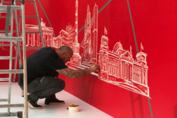 apeover bringt Tape-Linien der Berliner Skyline auf dem roten Backdrop zur 200-Jahre-Feier der Berliner Sparkasse 2018 an.