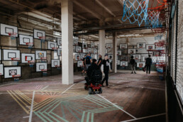 auminstallation mit zahlreichen Basketballkörben und Kunstwerken, Besucher bewegen sich durch die Ausstellung beim Monumenta Festival Leipzig 2018.
