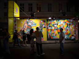 Besucher:innen vor einem Floating Mural, live bemalt von Guapo Sapo beim Straßenfest zur Urban Nation Ausstellungseröffnung.
