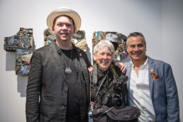 Martha Cooper und BSA posieren bei der Urban Nation Museum Eröffnung 2017, im Hintergrund Kunstwerke an der Wand.