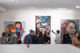 Besuchende vor großformatigen Werken bei der Urban Nation Museum Eröffnung 2017.