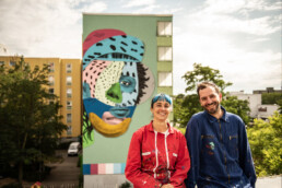 Porträt von Various & Gould vor dem fertigen One Wall Mural für Urban Nation in Berlin.