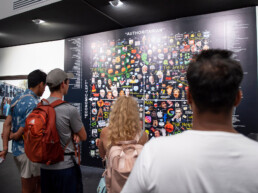 Publikum vor einer großformatigen Wandarbeit bei der Ausstellungseröffnung