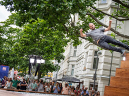 Live-Performance von Yoann Bourgeois beim Straßenfest UN-ARTig zur Ausstellungseröffnung „Talking and other banana skins“ im URBAN NATION Museum Berlin.
