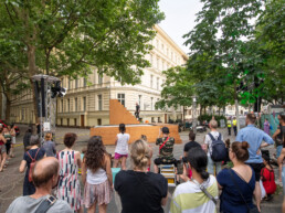 Publikum verfolgt die Live-Performance von Yoann Bourgeois auf einer Holz-Bühnenkonstruktion beim Straßenfest UN-ARTig in Berlin