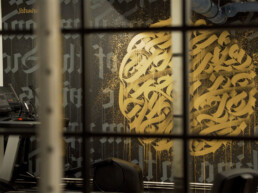 Detailaufnahme im Fitnessraum des Vienna House Easy by Wyndham Berlin: goldene Kalligrafie-Wandgestaltung von Parisurteil