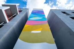 Detailaufnahme des Stohead-Murals mit fließenden Formen und sanfter Farbigkeit