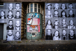 Zwei große Inside Out Porträtflächen aus Schwarzweiß-Fotos links und rechts einer Hausecke in Berlin.