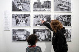 Besucherinnen im Austausch vor historischen Schwarz-Weiß-Fotografien von Martha Cooper in der Urban Nation Museumsausstellung.