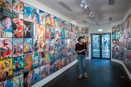 Besucherin betrachtet großformatige Fotowand mit Street-Art-Motiven in der Ausstellung „Martha Cooper: Taking Pictures“ im Urban Nation Museum.
