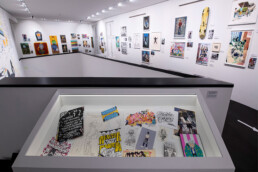 Vitrine mit Skizzen, Fotografien und Archivmaterial aus der Ausstellung „Martha Cooper: Taking Pictures“ im Urban Nation Museum.