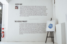 Wandtext zur Ausstellung THE VERSUS PROJECT von Layer Cake in den Räumen von URBAN NATION.