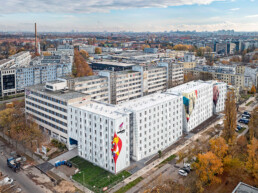 Luftaufnahme des Berlinovo-Gebäudekomplexes mit mehreren gestalteten Fassaden