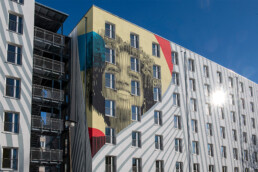 Fassadenkunst im schwarz-weißen Streifenlook, großformatiges Mural von Hundertzehn an der Gebäudeseite