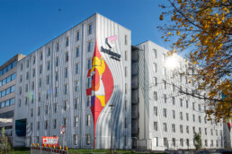 Gebäudeansicht mit berlinovo-Logo und farbigem Muralmotiv auf der Stirnseite